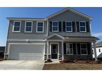 Charming two-story home with a garage and a well-maintained front yard on a clear, sunny day at 873 Agostino Dr., Myrtle Beach, SC 29579