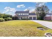 Charming two-story home with a well-manicured lawn and attached two-car garage at 1104 Plantation Dr., Surfside Beach, SC 29575