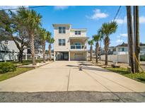 Charming elevated beach home with a spacious driveway and lush palm trees at 302A 32Nd Ave. N, North Myrtle Beach, SC 29582