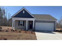 Charming single-story home featuring a covered front porch and attached two-car garage in a well-maintained community at 7287 Meadow Walk Loop, Loris, SC 29569