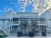 Inviting condo building with two stories and well-maintained light beige siding at 1095 West Plantation Dr. # 28-I, Little River, SC 29566