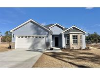 Charming one-story home featuring light blue siding, attached garage, and well-maintained landscaping under a clear blue sky at 4971 Old Highway 90, Conway, SC 29526