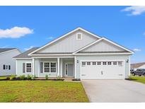 Charming single-story home with light blue siding, white trim, and a well-manicured lawn on a sunny day at 1203 Cypress Shoal Dr., Conway, SC 29526