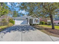 Charming single-story home with a well-manicured lawn and a cozy front porch, with a long drive to the garage at 138 Sugar Loaf Ln., Murrells Inlet, SC 29576