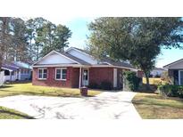 Charming brick home with red shutters, landscaped front yard, and a concrete driveway on a sunny day at 425 Spauldingwood Rd., Little River, SC 29566