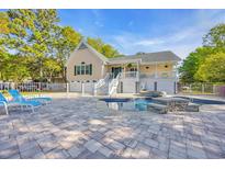 Backyard pool with well-maintained patio, a white fence, and a two-story home in the background at 437 N Boyle Dr., Pawleys Island, SC 29585