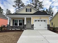 Charming yellow house with gray stone accents and a two-car garage at 3133 Tiger Tail Rd., Conway, SC 29526