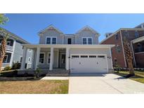 Charming two-story home featuring a welcoming front porch and an attached two-car garage at 5118 Middleton View Dr., Myrtle Beach, SC 29579