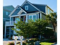 Charming coastal home with blue siding, white trim, and a well-manicured lawn, showcasing curb appeal at 253 W Second Ave. S, Ocean Isle Beach, NC 28469