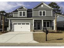 Charming gray two-story home featuring a two-car garage and a welcoming front porch at 3057 Moss Bridge Ln., Myrtle Beach, SC 29579