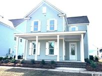 Charming two-story home featuring a welcoming front porch with classic white columns and window trim at 718 Macon Alley, Myrtle Beach, SC 29588
