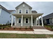 Charming two-story home featuring a welcoming front porch with white columns and shutters, offering classic curb appeal at 718 Macon Alley, Myrtle Beach, SC 29588