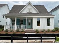 Charming single-Gathering home featuring a cozy front porch, white trim, and a well-manicured lawn at 734 Macon Alley, Myrtle Beach, SC 29588