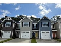Charming townhomes showcase varied siding, garage, and a well-manicured lawn under a bright, partly cloudy sky at 261 Christiana Ln. # C, Myrtle Beach, SC 29579