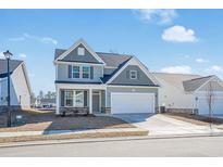 Charming two-story home with blue siding, stone accents, and a two-car garage on a sunny day at 2476 Campton Loop, Conway, SC 29527