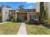 Charming townhome with lush landscaping and a welcoming walkway to the front door at 1100 Wedge Way # 67, Little River, SC 29566