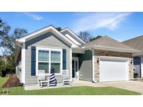 Charming single-Gathering home featuring stone accents, a two-car garage, and a welcoming front porch at 1178 Pyxie Moss Dr., Little River, SC 29566