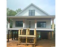 New construction home featuring a raised foundation and a charming front porch, offering a blend of style and functionality at 314 Hollywood Dr. S, Surfside Beach, SC 29575