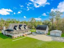 Stunning home boasts a sprawling lawn, charming front porch, additional garage, and separate building at 865 River Rd., Tabor City, SC 28463