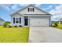 Charming exterior of a light blue home featuring a two-car garage, black shutters, and manicured landscaping at 1044 Jase Dr., Longs, SC 29568