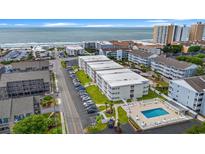 Beautiful aerial view of an oceanfront condo building with a pool, beach access, and parking at 191 Maison Dr. # B203, Myrtle Beach, SC 29572