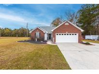 Charming single-story brick home with a well-manicured lawn and attached two-car garage, offering curb appeal at 1200 Bergen Dr., Loris, SC 29569