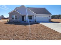 Charming single-story home with brick and vinyl siding, attached garage, and freshly seeded lawn at 2802 Daisy Rd., Loris, SC 29569