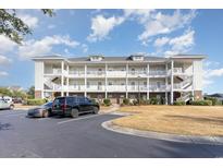 Multi-story condo building featuring white balconies and staircases, complemented by well-maintained landscaping at 505 Wickham Dr. # 1078, Myrtle Beach, SC 29579