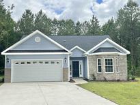 Charming single-story home with blue siding, a brick accent bay window, and an attached two-car garage at 6944 Highway 66, Loris, SC 29569