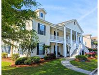 Charming two-story condo with inviting porch, well-kept lawn, and lush landscaping at 607 Sunnyside Dr. # 201, Murrells Inlet, SC 29576