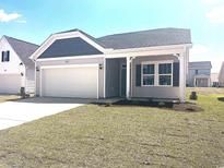 Charming single-story home featuring a well-manicured lawn, attached garage, and covered front porch at 1200 Nw Calabash Station Blvd., Calabash, NC 28467