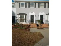 Charming townhome featuring black shutters, black doors, and lovely bay window, providing an inviting curb appeal at 2925 Carriage Row Ln. # 145, Myrtle Beach, SC 29577