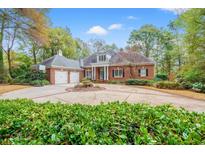 Stately brick home with circular driveway, two-car garage, manicured landscaping, and inviting entry at 4511 Saint Johns Pl., Murrells Inlet, SC 29576