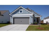 Charming single-story home with light blue siding, gray garage door, and a well-maintained front lawn at 1241 Crested Iris Way, North Myrtle Beach, SC 29582