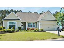 Charming single-story home with well-manicured lawn and colorful flowerbeds leading to an attached two-car garage at 64 Summerlight Dr., Murrells Inlet, SC 29576