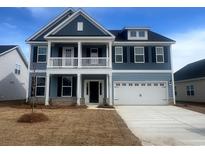 Charming two-story home with a blue exterior, a two-car garage, and a welcoming front porch at 348 Happy Valley Dr., Myrtle Beach, SC 29588