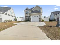 Inviting two-story home with a two car garage, stone accents, and a well-manicured front yard at 724 Hobonny Loop, Longs, SC 29568