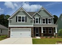 Charming two-story home features a two-car garage and manicured lawn at 561 Slaty Dr., Myrtle Beach, SC 29588