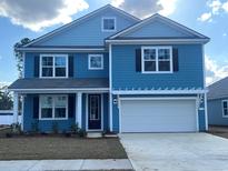 Charming two-story home with blue siding, black shutters, and a two-car garage at 574 Haven View Way, Murrells Inlet, SC 29576