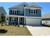 Charming two-story home featuring a two-car garage, manicured lawn, and stylish blue siding at 574 Haven View Way, Murrells Inlet, SC 29576