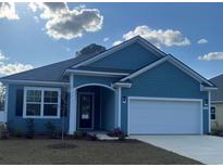 Charming single-story home featuring blue siding, an attached garage, and a welcoming front porch at 586 Haven View Way, Murrells Inlet, SC 29576