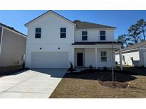 Charming two-story home featuring a clean white exterior, attached garage, and a well-manicured front yard at 977 Laconic Dr., Myrtle Beach, SC 29588