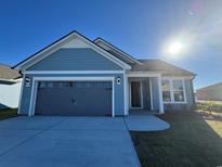 Newly built home with gray garage and light blue siding at 1310 Crested Iris Way, North Myrtle Beach, SC 29582