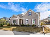 Charming two-story home featuring neutral siding, complementary trim, manicured landscaping, and a well-maintained lawn at 1711 Sapphire Dr., Longs, SC 29568