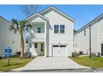 Charming two-story home with white siding, a yellow front door, and a single-car garage at 2624 Hillbourne Loop, North Myrtle Beach, SC 29582