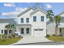 Charming two-story home with a crisp white exterior, inviting curb appeal, and an attached one car garage at 2628 Hillbourne Loop, North Myrtle Beach, SC 29582