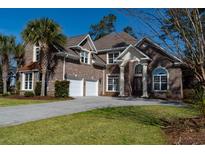 Stunning brick home featuring a manicured lawn, a two-car garage, and an inviting entrance at 1038 Johnston Dr., Myrtle Beach, SC 29588