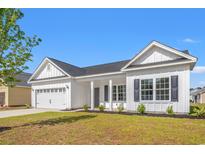 Charming exterior view of a white home with a well-manicured lawn and two-car garage at 1209 Cypress Shoal Dr., Conway, SC 29526