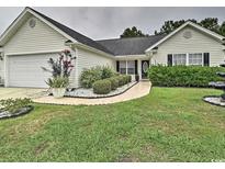 Charming single-story home featuring a two-car garage, manicured lawn and walkway leading to the front door at 2707 Wood Creek Ln., Conway, SC 29527