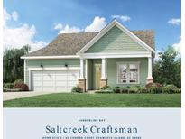 Craftsman style home with green siding, two-car garage, and landscaped lawn at 63 Condor Ct, Pawleys Island, SC 29585